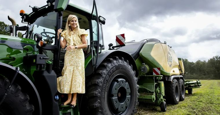 Koningin Máxima kruipt achter het stuur van trekker tijdens werkbezoek Koninklijk Huis